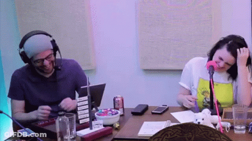 Man And Woman At Table With Microphone And Candy GIF