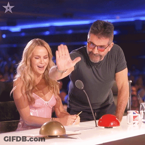 Man And Woman At Table With Microphone And Red Button GIF
