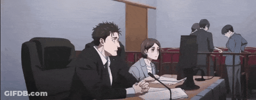 Man And Woman At Table With Microphones In Courtroom GIF
