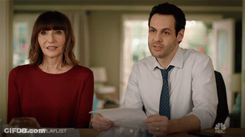 Man And Woman At Table With NBC Logo GIF
