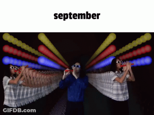 Man And Woman Blowing Bubbles In Front Of September Sign GIF