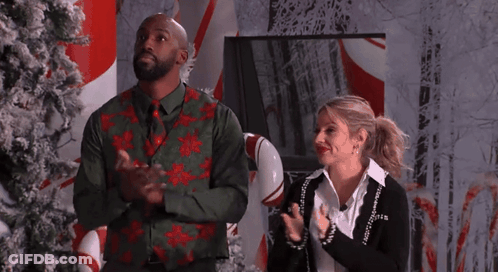 Man And Woman Clapping In Front Of Candy Cane Display GIF