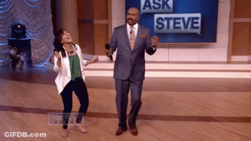 Man And Woman Dancing In Front Of Ask Steve Sign GIF