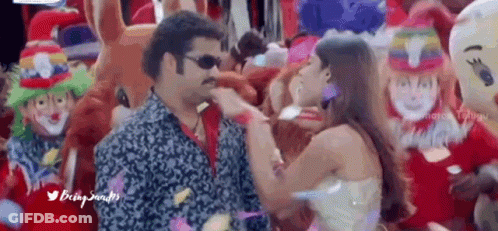 Man And Woman Dancing In Front Of Clowns And Balloons GIF