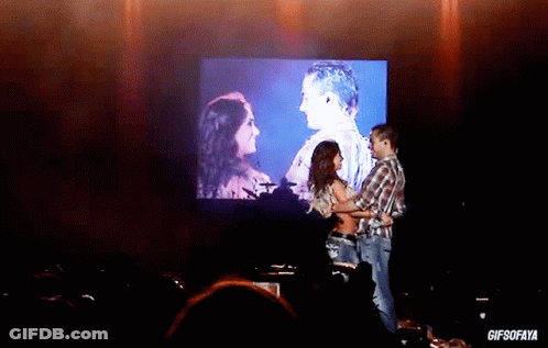 Man And Woman Dancing In Front Of GIFSOFAYA Screen GIF