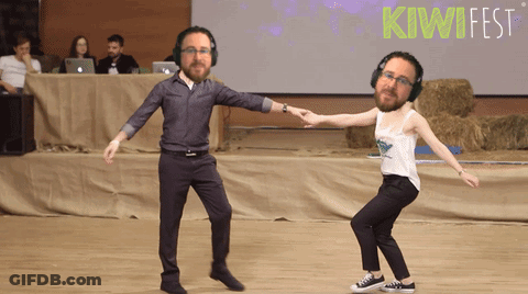 Man And Woman Dancing In Front Of Kiwifest Sign GIF