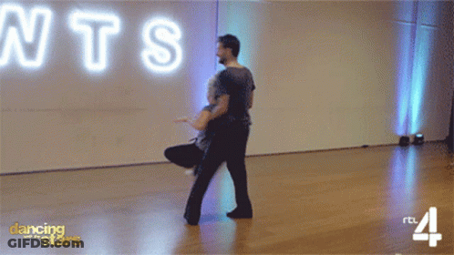 Man And Woman Dancing In Front Of Neon Sign Saying NTS GIF