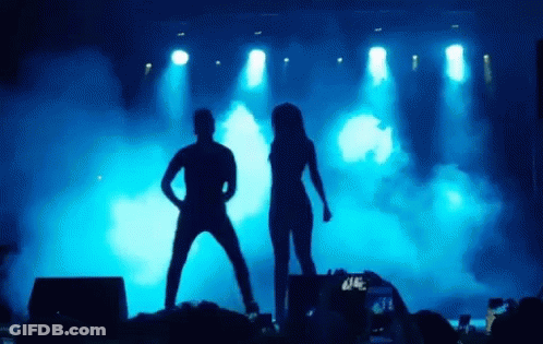 Man And Woman Dancing On Stage Before Crowd GIF
