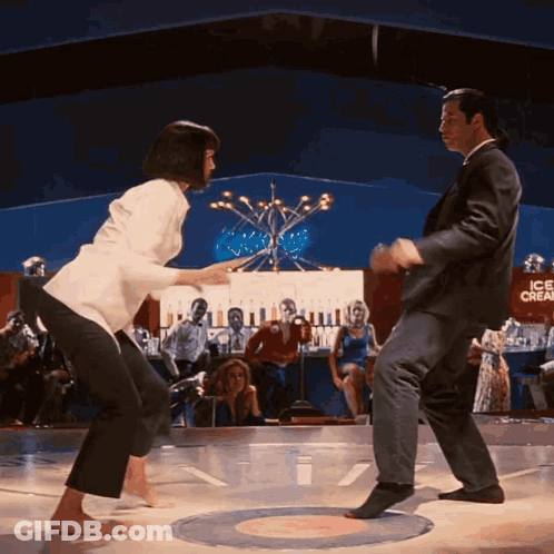 Man And Woman Dancing On Stage In Front Of Ice Cream Sign GIF