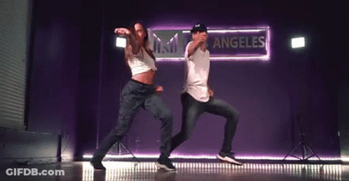 Man And Woman Dancing On Stage In Front Of Sessions Sign GIF