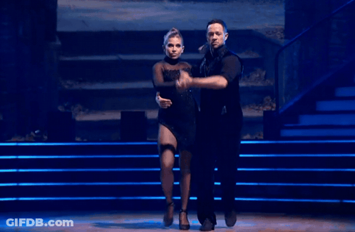 Man And Woman Dancing On Stage With Blue Lights GIF