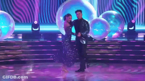 Man And Woman Dancing On Stage With Bubbles GIF