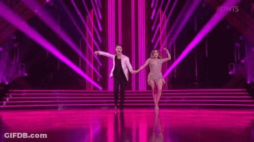 Man And Woman Dancing On Stage With Purple Light GIF