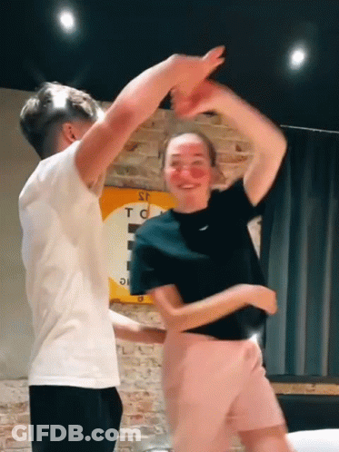 Man And Woman Dancing Under S.T.C. Sign GIF