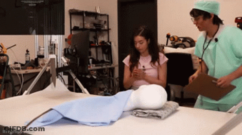 Man And Woman Doctors Looking At Mannequin GIF