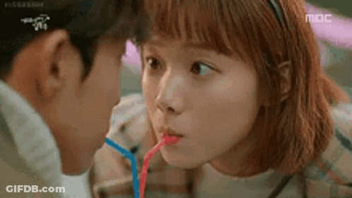 Man And Woman Drinking Through Straws GIF