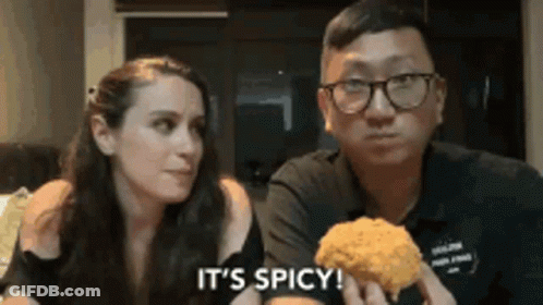Man And Woman Eating Fried Chicken Saying It's Spicy GIF