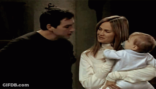 Man And Woman Holding Baby With Pacifier GIF