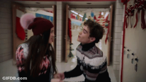 Man And Woman Holding Hands In Christmas Hallway GIF