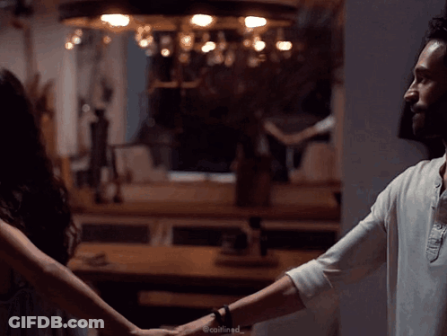Man And Woman Holding Hands In Dark Room GIF