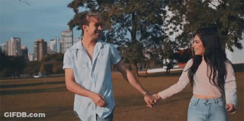 Man And Woman Holding Hands In Park GIF