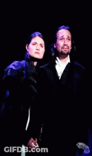 Man And Woman Holding Hands On Stage GIF