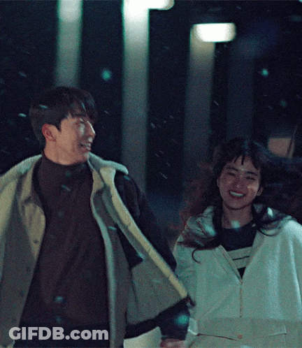 Man And Woman Holding Hands Smiling In Snow GIF