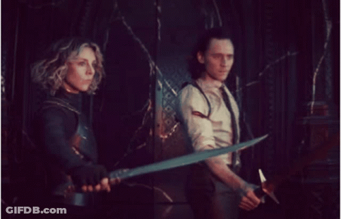 Man And Woman Holding Swords In Dark Room GIF