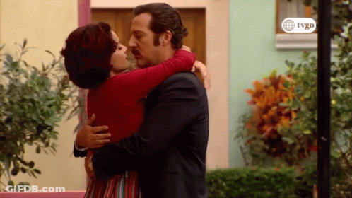 Man And Woman Hugging And Kissing In Front Of Building GIF