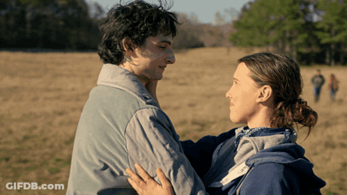 Man And Woman Hugging In Field With Trees GIF