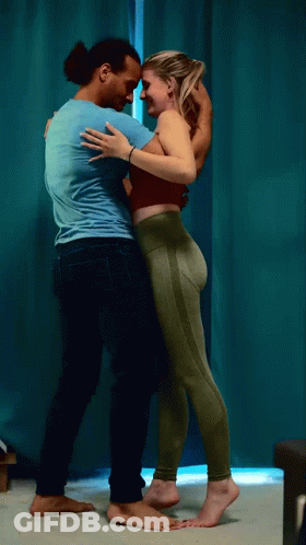 Man And Woman Hugging In Front Of Blue Curtain GIF