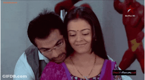 Man And Woman Hugging In Front Of Bollywood Sign GIF