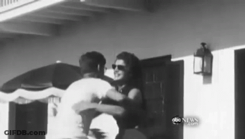 Man And Woman Hugging In Front Of Building GIF