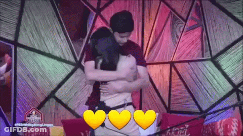 Man And Woman Hugging In Front Of Colorful Background GIF