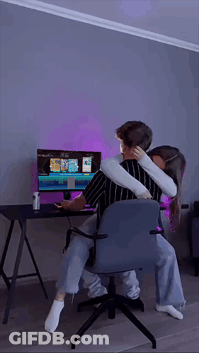 Man And Woman Hugging In Front Of Computer Monitor GIF