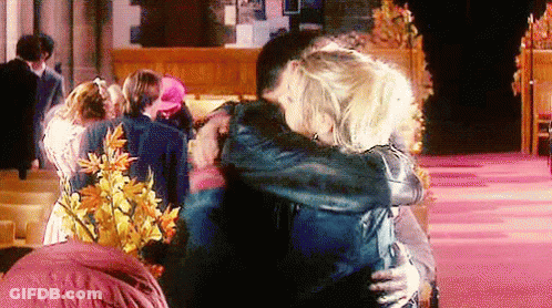 Man And Woman Hugging In Front Of Crowd GIF