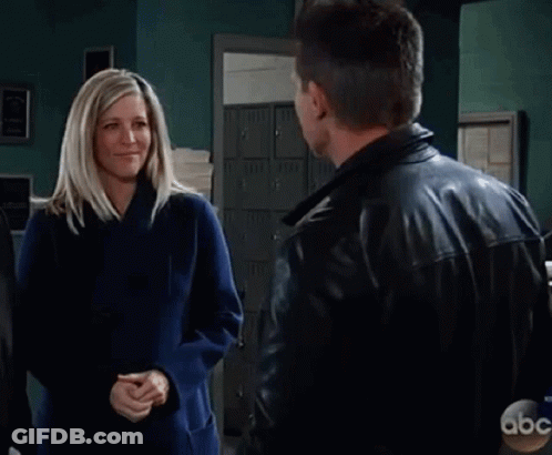 Man And Woman Hugging In Front Of Exit Sign GIF