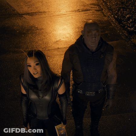 Man And Woman Hugging In Front Of Lit Fence GIF