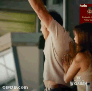 Man And Woman Hugging In Front Of Wrexham Sign GIF