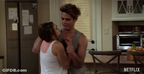 Man And Woman Hugging In Kitchen With Netflix Logo GIF