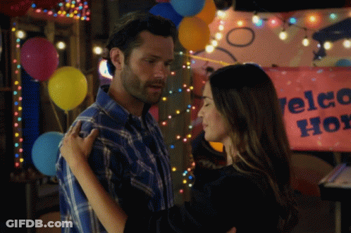 Man And Woman Hugging Welcome Home Sign GIF