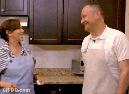 Man And Woman In Aprons In Kitchen GIF