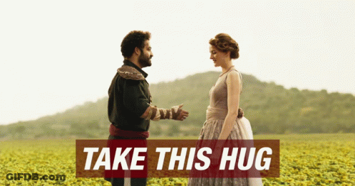 Man And Woman In Field Saying Take This Hug GIF