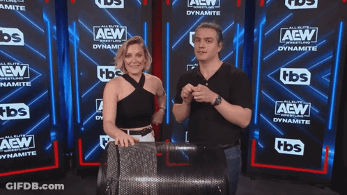 Man And Woman In Front Of AEW Wall GIF