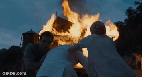 Man And Woman In Front Of Burning Building GIF