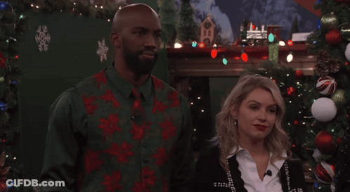 Man And Woman In Front Of Christmas Tree And Fireplace GIF
