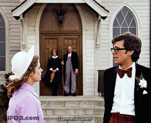 Man And Woman In Front Of Church With Dammit Janet On Steps GIF