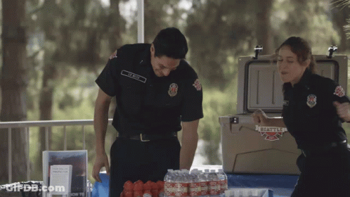 Man And Woman In Front Of Cooler Saying Seattle Fire GIF
