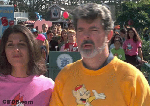 Man And Woman In Front Of Disneyland Sign GIF