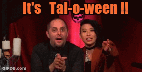 Man And Woman In Front Of It's Tal-O-Ween Sign GIF